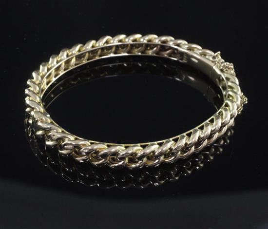 An early 20th century 15ct gold curb link hinged bangle, 20 grams.